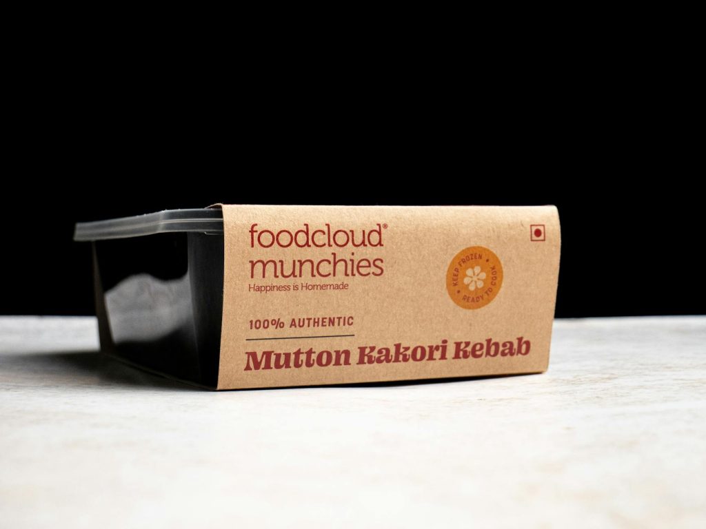 Close-up of mutton kakori kebab packaging with a black background, showcasing food branding concept.