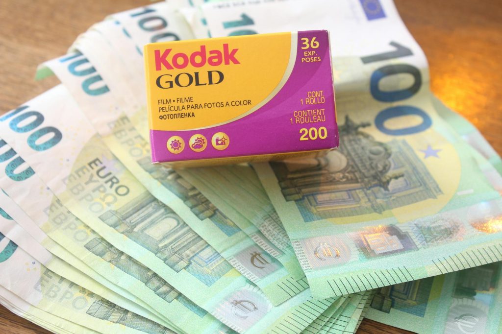 Close-up of Kodak Gold film box placed on 100 euro banknotes.