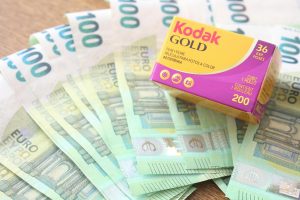 Kodak Gold 200 film box placed atop 100 euro banknotes in a vibrant image.