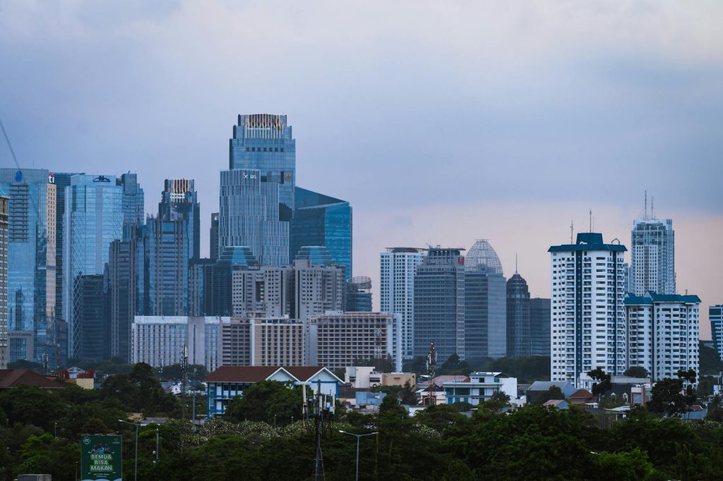 Discover Jakarta's dynamic skyline, featuring modern skyscrapers under a blue sky.